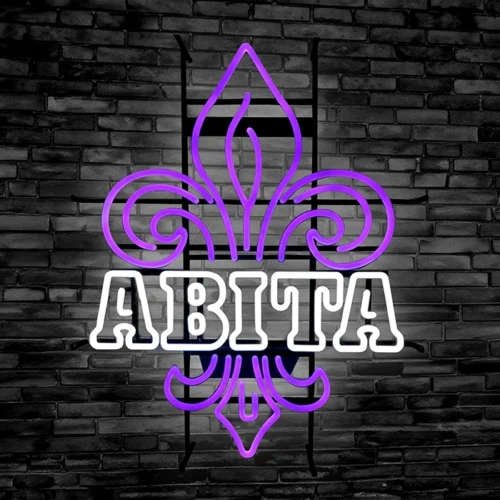 A custom purple LED neon sign with the word abita on it against a black brick wall