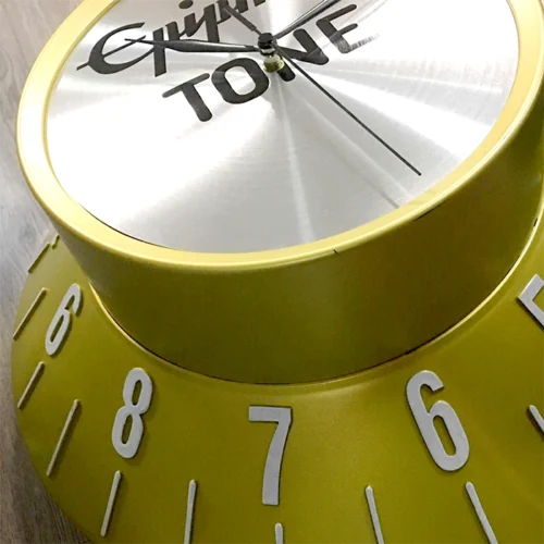 A **yellow** clock on a wooden table.