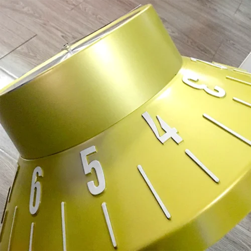 A yellow clock with numbers on it.