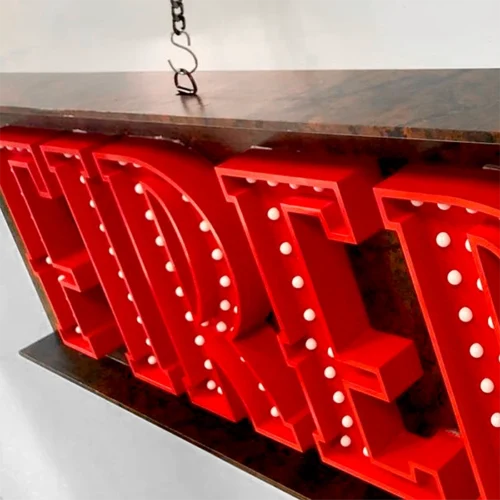 A **non-illuminated** red and white Fireball sign hanging on a wall.