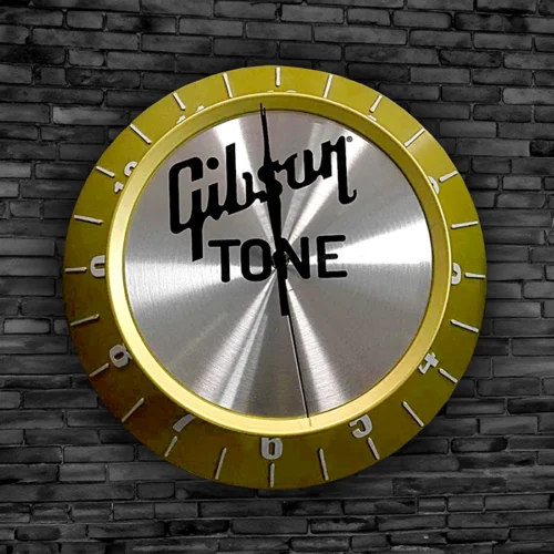A Gibson Tone nob clock on a brick wall.