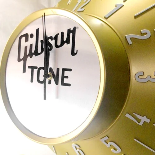 A non-illuminated Clock with Gibson Tone logo on it.