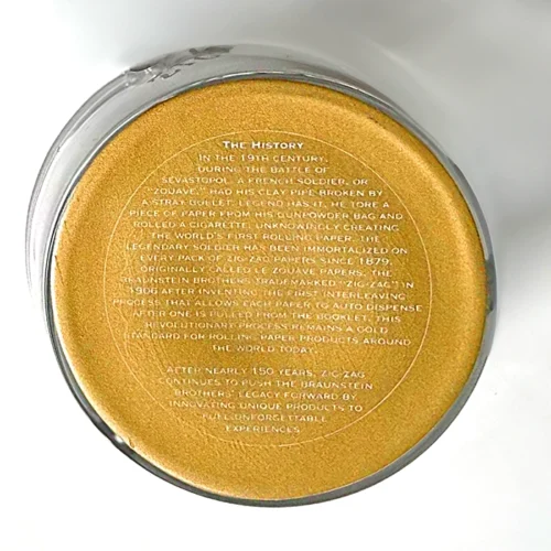 A close up of a zig zag ash tray with their history at the bottom.