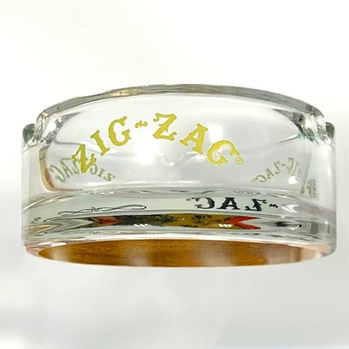 A glass ashtray with the word "zig zag" etched on it.