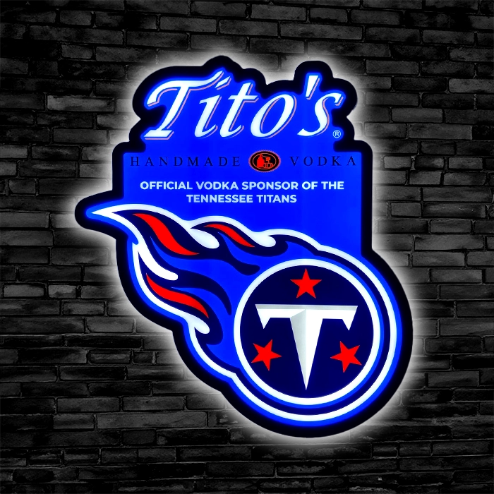 LED sign of Tito's Handmade Vodka on a brick wall, featuring the Tennessee Titans logo, labeled as the official vodka sponsor of the team.
