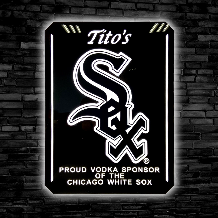 Illuminated custom LED sign for Tito's Vodka featuring the Chicago White Sox logo, mounted on a brick wall, stating "Proud Vodka Sponsor of the Chicago White Sox.