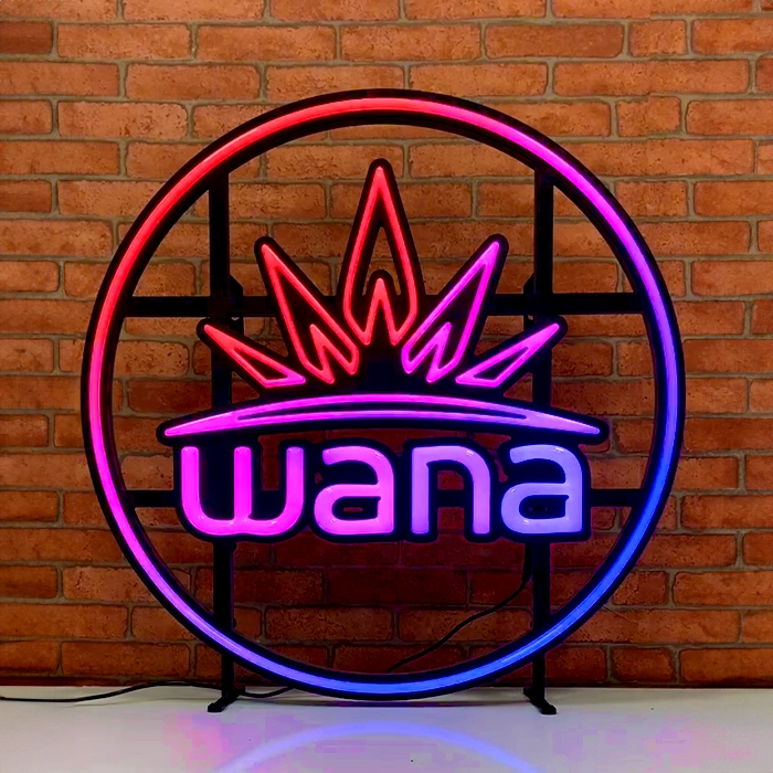 Custom LED Neon sign made with color changing motion LEDs with the word "wana" inside a circular frame, featuring a crown design, displayed against a brick wall. This is a custom led neon sign.