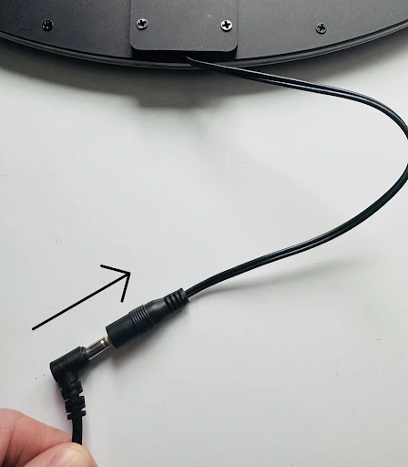 Close up od the back of an LED sign power cord plugging into the input port .