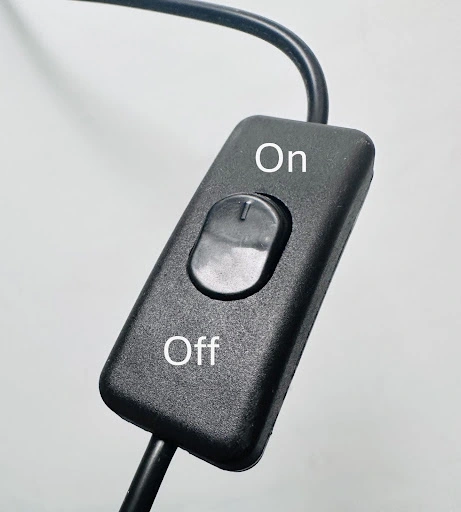 CLose up of a black LED Sign power supply switch showing up as the on position and down as the off.