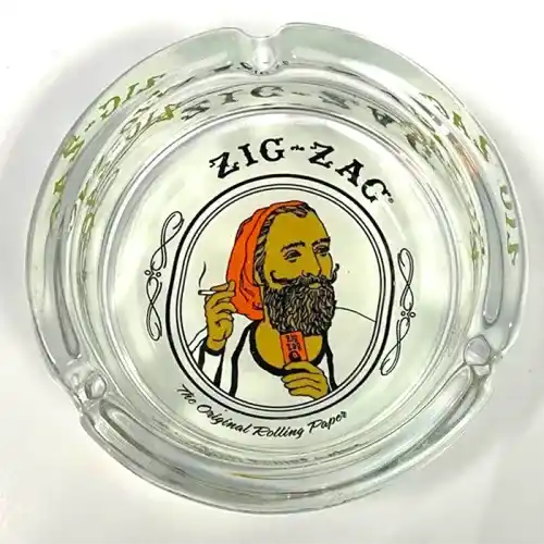 A glass ashtray with the image of a bearded man, perfect for Zig Zag